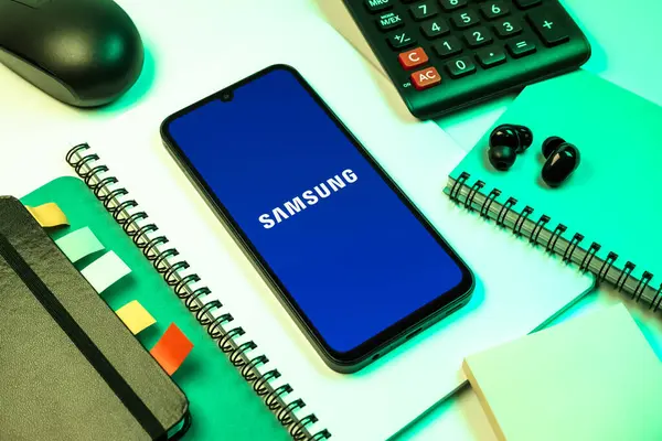 Prag, Çek Cumhuriyeti - 08 18 2025: Merkezde Samsung logosu sergilenen bir cep telefonu ile ofis malzemeleri düzenlemesi. Samsung elektronik ve cihaz üreten bir teknoloji şirketi..