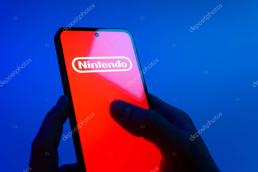 Prague, Czechia - 08 12 2025: Hands on a blue background are holding a mobile phone displaying the Discord logo. Discord is a platform for voice, video, and text communication.