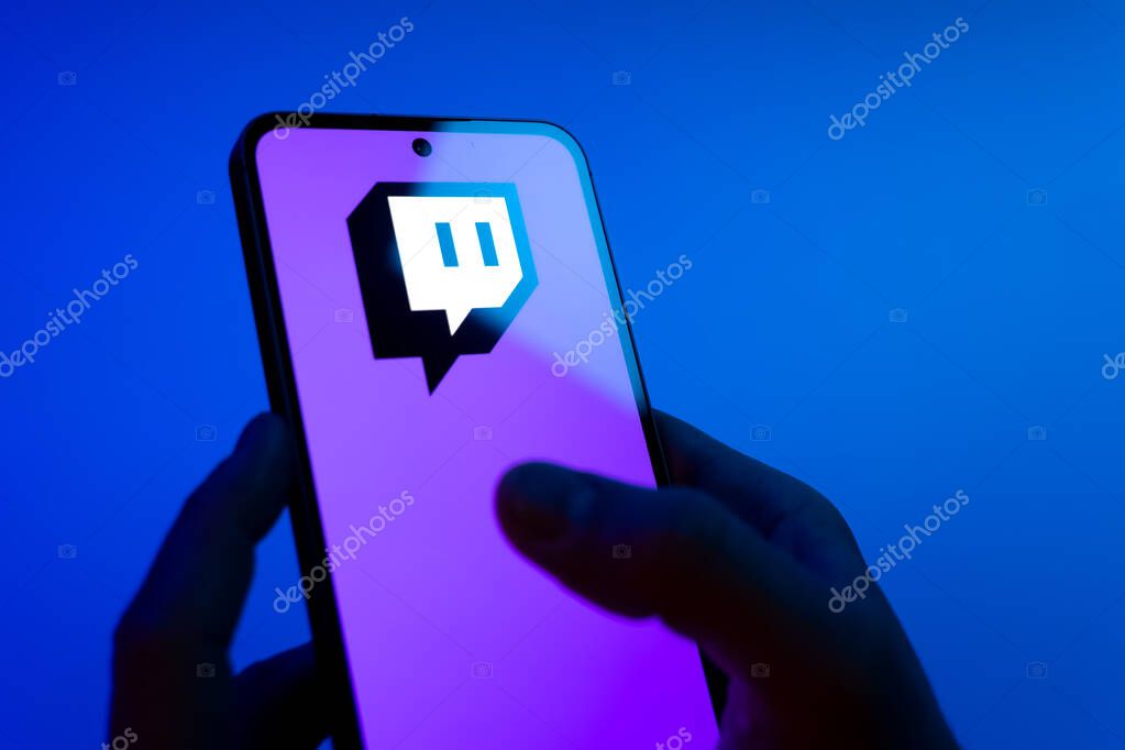 Prague, Czechia - 08 12 2025: Hands on a blue background are holding a mobile phone displaying the Discord logo. Discord is a platform for voice, video, and text communication.