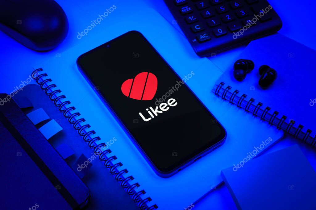 Prague, Czechia - 08 18 2025: An arrangement of office supplies with a mobile phone in the center displaying Likee logo. Likee is a platform for creating and sharing short videos.