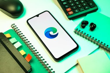 Prag, Çek Cumhuriyeti - 08 18 2025: Merkezde Edge logosunu gösteren bir cep telefonu ile ofis malzemeleri düzenlemesi. Edge, Microsoft tarafından Windows aygıtları için geliştirilen bir web tarayıcısıdır..