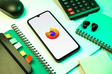 Prag, Çek Cumhuriyeti - 08 18 2025: Merkezde Firefox logosunu gösteren bir cep telefonu ile ofis malzemeleri düzenlemesi. Firefox hızlı ve güvenli internet taraması için bir web tarayıcısıdır.