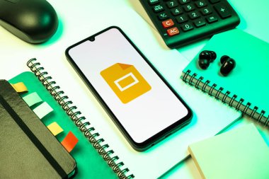 Prag, Çek Cumhuriyeti - 08 18 2025: Merkezde Google Slides logosunu gösteren bir cep telefonu ile ofis malzemeleri düzenlemesi. Google Slides sunumlar ve slayt gösterileri oluşturmak için bir platformdur.