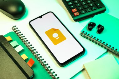 Prag, Çek Cumhuriyeti - 08 18 2025: Merkezde Google Keep logosu sergilenen bir cep telefonu ile ofis malzemeleri düzenlemesi. Google Keep notlar, listeler ve hatırlatıcılar için bir platformdur.