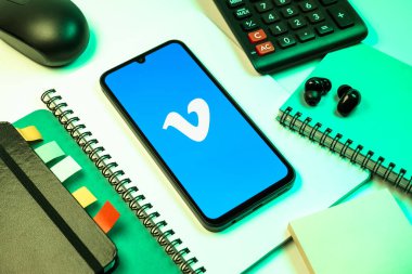 Prag, Çek Cumhuriyeti - 08 18 2025: Merkezde Vimeo logosunu gösteren bir cep telefonu ile ofis malzemeleri düzenlemesi. Vimeo, yüksek kaliteli video sunucu ve paylaşımı için bir platformdur.