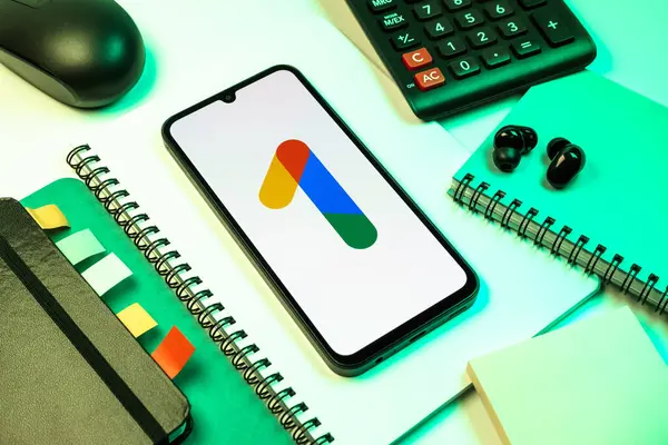 Prag, Çek Cumhuriyeti - 08 18 2025: Merkezinde Google One logosu bulunan bir cep telefonu ile ofis malzemeleri düzenlemesi. Google 1 bulut depolama ve abonelik hizmetleri için bir platformdur.