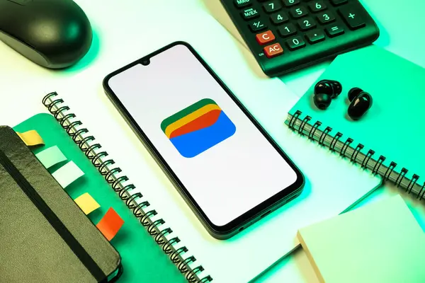 Prag, Çek Cumhuriyeti - 08 18 2025: Merkezde Google Cüzdan logosunu gösteren bir cep telefonu ile ofis malzemeleri düzenlemesi. Google Cüzdanı dijital ödeme yöntemlerini depolamak ve kullanmak için bir platformdur.