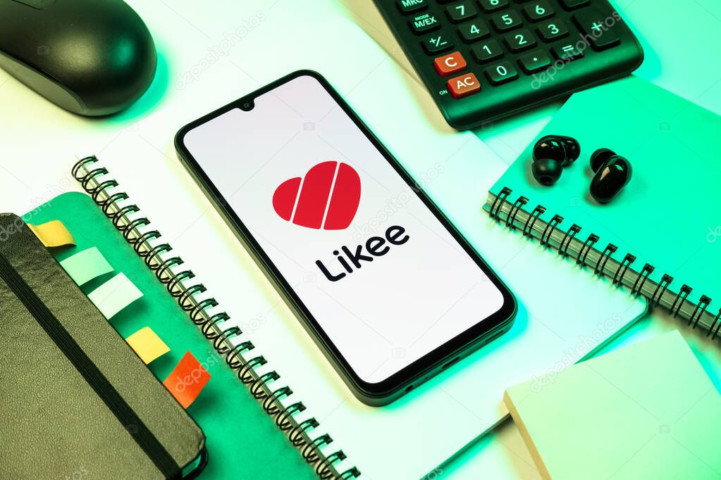 Prague, Czechia - 08 18 2025: An arrangement of office supplies with a mobile phone in the center displaying Likee logo. Likee is a platform for creating and sharing short videos.