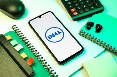 Prag, Çek Cumhuriyeti - 08 18 2025: Merkezde Dell logosunu gösteren bir cep telefonu ile ofis malzemeleri düzenlemesi. Dell bilgisayar ve bilişim çözümleri üreten bir teknoloji şirketidir..