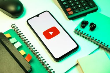 Prag, Çek Cumhuriyeti - 08 18 2025: Merkezde Youtube logosu sergilenen bir cep telefonu ile ofis malzemeleri düzenlemesi. Youtube dünya çapında videoları izlemek ve paylaşmak için bir platform.