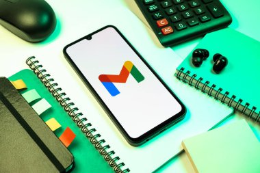 Prag, Çek Cumhuriyeti - 08 18 2025: Merkezde Google Gmail logosunu gösteren bir cep telefonu ile ofis malzemeleri düzenlemesi. Google Gmail, mesaj göndermek ve almak için kullanılan bir e-posta servisidir..