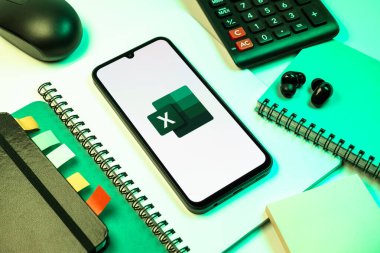 Prag, Çek Cumhuriyeti - 08 18 2025: Excel logosu sergilenen bir cep telefonu ile ofis malzemeleri düzenlemesi. Excel, tablo, veri analizi ve hesaplamalar için bir yazılımdır..