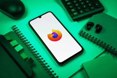 Prag, Çek Cumhuriyeti - 08 18 2025: Merkezde Firefox logosunu gösteren bir cep telefonu ile ofis malzemeleri düzenlemesi. Firefox hızlı ve güvenli internet taraması için bir web tarayıcısıdır.