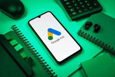 Prag, Çek Cumhuriyeti - 08 18 2025: Merkezde Google Ads logosunu gösteren bir cep telefonu ile ofis malzemeleri düzenlemesi. Google Reklamları, çevrimiçi reklamlar yaratmak ve yönetmek için bir platformdur.