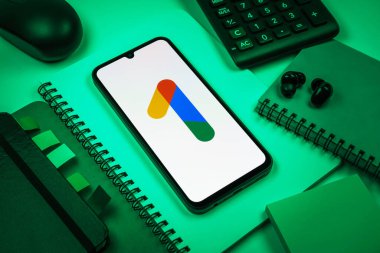Prag, Çek Cumhuriyeti - 08 18 2025: Merkezinde Google One logosu bulunan bir cep telefonu ile ofis malzemeleri düzenlemesi. Google 1 bulut depolama ve abonelik hizmetleri için bir platformdur.