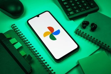 Prag, Çek Cumhuriyeti - 08 18 2025: Merkezde Google Photos logosunu gösteren bir cep telefonu ile ofis malzemeleri düzenlemesi. Google Fotoğrafları fotoğraf ve videoları saklamak ve düzenlemek için bir platformdur.