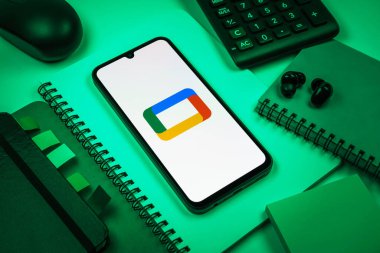 Prag, Çek Cumhuriyeti - 08 18 2025: Merkezde Google TV logosunu gösteren bir cep telefonu ile ofis malzemeleri düzenlemesi. Google TV film, program ve uygulamalar için bir platformdur..