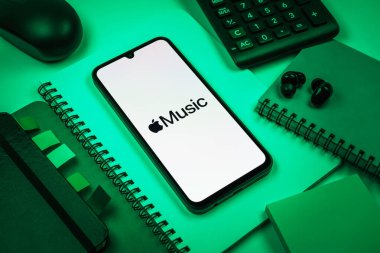 Prag, Çek Cumhuriyeti - 08 18 2025: Merkezinde Apple Music logosu sergilenen bir cep telefonu ile ofis malzemeleri düzenlemesi. Apple Music müzik için bir platformdur..