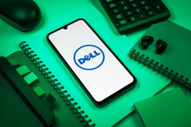 Prag, Çek Cumhuriyeti - 08 18 2025: Merkezde Dell logosunu gösteren bir cep telefonu ile ofis malzemeleri düzenlemesi. Dell bilgisayar ve bilişim çözümleri üreten bir teknoloji şirketidir..