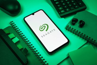 Prag, Çek Cumhuriyeti - 08 18 2025: Seagate logosunu gösteren bir cep telefonu ile ofis malzemeleri düzenlemesi. Seagate sabit disk ve depolama çözümleri üreten bir şirkettir..