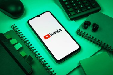Prag, Çek Cumhuriyeti - 08 18 2025: Merkezde Youtube logosu sergilenen bir cep telefonu ile ofis malzemeleri düzenlemesi. Youtube dünya çapında videoları izlemek ve paylaşmak için bir platform.