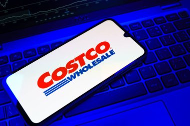 Prag, Çek Cumhuriyeti - 08 18 2025: Klavyede bir cep telefonu Costco logosu sergiler. Costco toptan satış yapan bir perakendecidir. Üyelere toptan ürün satar..
