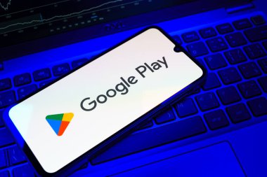 Prag, Çek Cumhuriyeti - 08 18 2025: Bir klavyede bir cep telefonu Google Play logosunu görüntüler. Google Play uygulamaları, oyunları ve dijital içeriği indirmek için bir platformdur.
