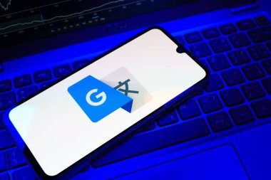 Prag, Çek Cumhuriyeti - 08 18 2025: Bir klavyede bir cep telefonu Google Translate logosunu görüntüler. Google Çevirisi metni ve konuşmayı diller arası çevirmek için bir platformdur..