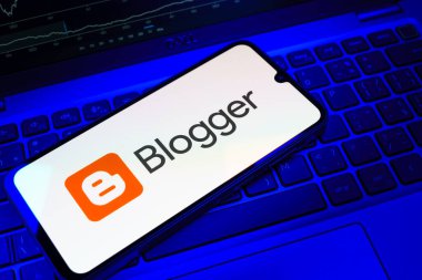 Prag, Çek Cumhuriyeti - 08 18 2025: Klavyede bir cep telefonu Blogger logosunu gösterir. Blogger blog oluşturma ve yayınlama için bir platformdur.