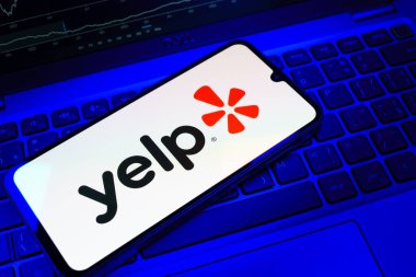 Prag, Çek Cumhuriyeti - 08 18 2025: Klavyede bir cep telefonu Yelp logosu sergiler. Yelp yerel işletmeleri bulmak ve incelemek için bir platformdur.
