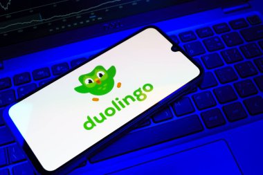 Prag, Çek Cumhuriyeti - 08 18 2025: Klavyede bir cep telefonu Duolingo logosu sergiler. Duolingo interaktif olarak dil öğrenmek için bir platformdur..