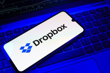 Prag, Çek Cumhuriyeti - 08 18 2025: Klavyede bir cep telefonu Dropbox logosu sergiler. Dropbox bulut depolama ve dosya paylaşımı için bir platformdur.