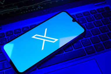 Prag, Çek Cumhuriyeti - 08 18 2025: Klavyede bir cep telefonu X logosu sergiler. X, kısa gönderileri ve güncellemeleri paylaşmak için bir platformdur.