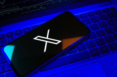 Prag, Çek Cumhuriyeti - 08 18 2025: Klavyede bir cep telefonu X logosu sergiler. X, kısa gönderileri ve güncellemeleri paylaşmak için bir platformdur.