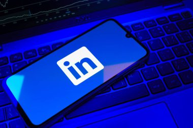 Prag, Çek Cumhuriyeti - 08 18 2025: Klavyede bir cep telefonu LinkedIn logosunu gösterir. LinkedIn, insanları ve şirketleri birbirine bağlayan profesyonel bir ağ..