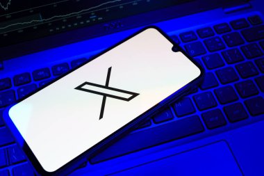 Prag, Çek Cumhuriyeti - 08 18 2025: Klavyede bir cep telefonu X logosu sergiler. X, kısa gönderileri ve güncellemeleri paylaşmak için bir platformdur.