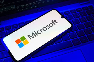 Prag, Çek Cumhuriyeti - 08 18 2025: Klavyede bir cep telefonu Microsoft logosu sergiler. Microsoft yazılım, donanım ve hizmet sunan bir teknoloji şirketidir..