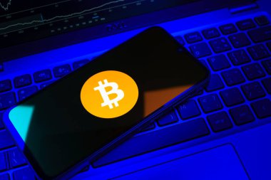 Prag, Çek Cumhuriyeti - 08 18 2025: Klavyede bir cep telefonu Bitcoin logosu sergiler. Bitcoin merkezi olmayan işlemler için dijital bir kripto para birimidir.