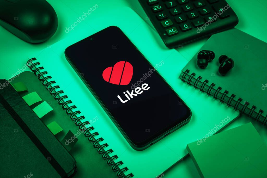 Prague, Czechia - 08 18 2025: An arrangement of office supplies with a mobile phone in the center displaying Likee logo. Likee is a platform for creating and sharing short videos.