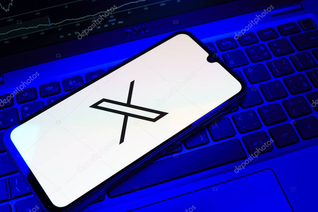 Prague, Czechia - 08 18 2025: A mobile phone on a keyboard displays X logo. X is a platform for sharing short posts and updates.