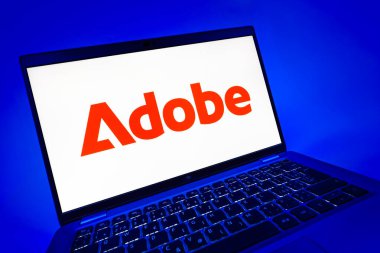 Prag, Çek Cumhuriyeti - 08 12 2025: Adobe logosunu gösteren bir dizüstü bilgisayarın dinamik yakın çekimi. Adobe yaratıcı araçlar ve hizmetler sunan bir yazılım şirketidir..