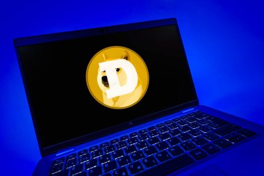 Prag, Çek Cumhuriyeti - 08 12 2025: Dogecoin logosunu gösteren bir dizüstü bilgisayarın dinamik yakın çekimi. Dogecoin, paylaşımcı işlemler için kullanılan bir şifreli para birimidir.