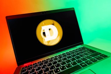 Prag, Çek Cumhuriyeti - 08 12 2025: Dogecoin logosunu gösteren bir dizüstü bilgisayarın dinamik yakın çekimi. Dogecoin, paylaşımcı işlemler için kullanılan bir şifreli para birimidir.