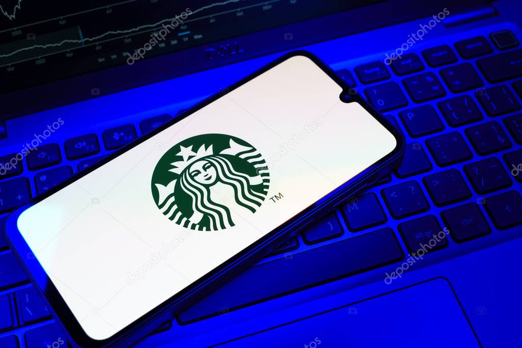 Prague, Czechia - 08 18 2025: A mobile phone on a keyboard displays Starbucks logo. Starbucks is a global coffeehouse chain serving beverages and food.