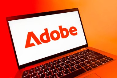 Prag, Çek Cumhuriyeti - 08 12 2025: Adobe logosunu gösteren bir dizüstü bilgisayarın dinamik yakın çekimi. Adobe yaratıcı araçlar ve hizmetler sunan bir yazılım şirketidir..