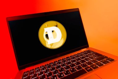 Prag, Çek Cumhuriyeti - 08 12 2025: Dogecoin logosunu gösteren bir dizüstü bilgisayarın dinamik yakın çekimi. Dogecoin, paylaşımcı işlemler için kullanılan bir şifreli para birimidir.