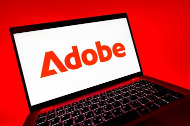 Prag, Çek Cumhuriyeti - 08 12 2025: Adobe logosunu gösteren bir dizüstü bilgisayarın dinamik yakın çekimi. Adobe yaratıcı araçlar ve hizmetler sunan bir yazılım şirketidir..