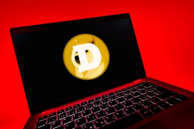 Prag, Çek Cumhuriyeti - 08 12 2025: Dogecoin logosunu gösteren bir dizüstü bilgisayarın dinamik yakın çekimi. Dogecoin, paylaşımcı işlemler için kullanılan bir şifreli para birimidir.