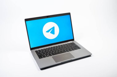 Prag, Çek Cumhuriyeti - 08 12 2025: Tek tip bir arkaplanda Telegram logosunu gösteren bir dizüstü bilgisayarın yukarıdan görünüşü. Telgraf hızlı ve güvenli iletiler için bir uygulamadır.