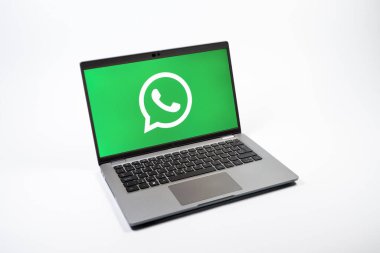 Prag, Çek Cumhuriyeti - 08 12 2025: Tek bir arkaplanda WhatsApp logosunu gösteren bir dizüstü bilgisayarın yukarıdan görünüşü. WhatsApp mesaj, çağrı ve medya göndermek için bir uygulamadır.